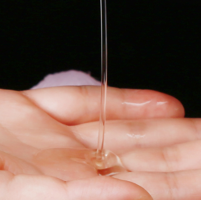 Coconut wax pouring from Aromatherapy Massage Candle for sex into a hand, showcasing its body-safe low-temperature oil.