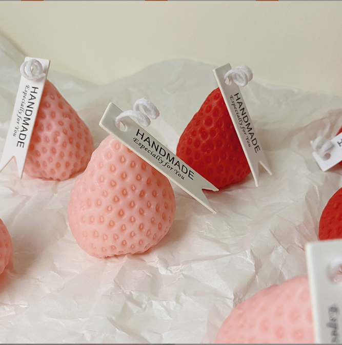 Strawberry Low Temp Candle featuring handmade strawberry-shaped wax candles in soft pink and vibrant red.