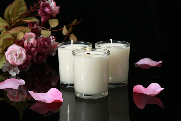Aromatherapy Massage Candle for sex, coconut wax, arranged with flower petals, creating a sensual ambiance.
