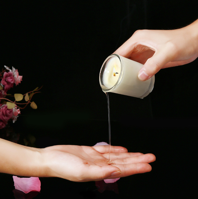 Aromatherapy Massage Candle for sex being poured onto a hand, showcasing coconut wax oil and sensual use.