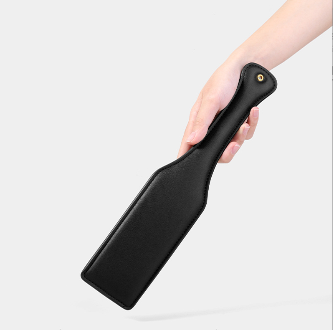 BDSM Spanking Toys Leather Paddles held in hand, showcasing its sleek black design and exquisite craftsmanship.